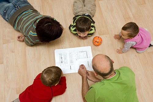 A family gathered around architectural plans.