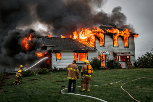 firefighters try to extinguish a burning house