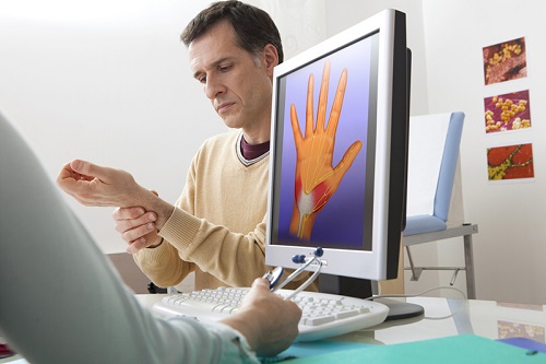 Carpal tunnel syndrome - health care provider and patient with a diagram of the wrist