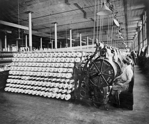 Women in a factory working on an early industrial loom