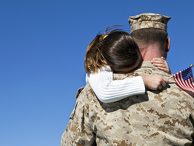 Father in military hugging his daughter goodbye